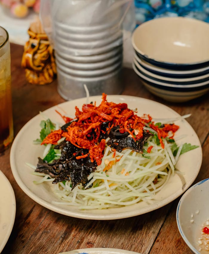 why-choose-us-02 A vibrant Asian papaya salad featuring dried shrimp, fresh greens, and vegetables.