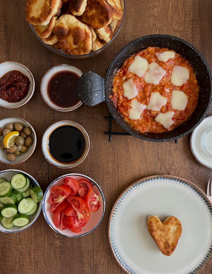 Delicious Turkish breakfast featuring menemen, olives, and fresh vegetables.